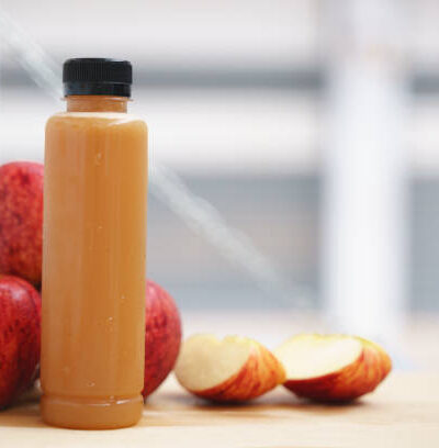 Cold pressed pure apple fruit juice from slow juicer in plastic bottle