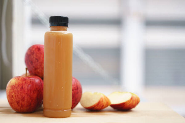Cold pressed pure apple fruit juice from slow juicer in plastic bottle