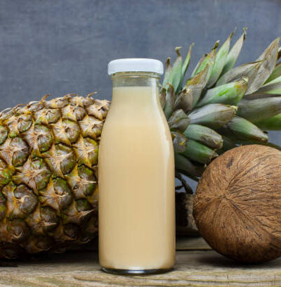 Organic smoothie pineapple and coconut juice bottle on wooden background