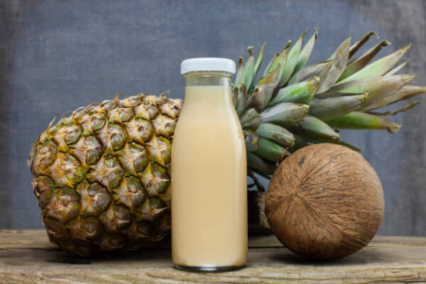 Organic smoothie pineapple and coconut juice bottle on wooden background