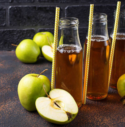 Bottles with fresh apple juice . selective focus